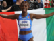Foto Grana/FIDAL: Zaynab Dosso in azione e poi avvolta dalla bandiera tricolore ai Mondiali indoor, dove ha conquistato il bronzo.